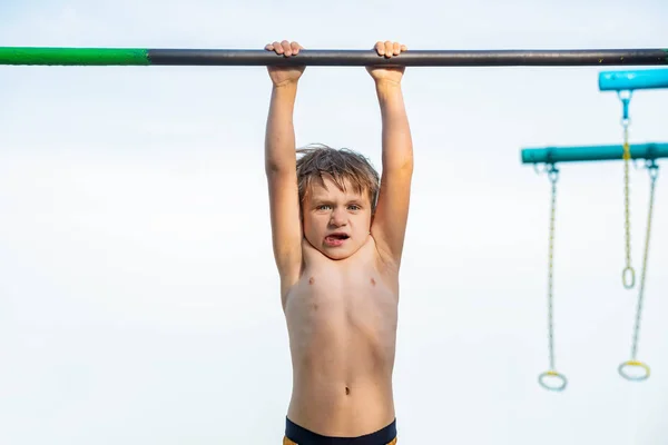 Un bambino è appeso sulla barra orizzontale e non può fare nulla . — Foto Stock