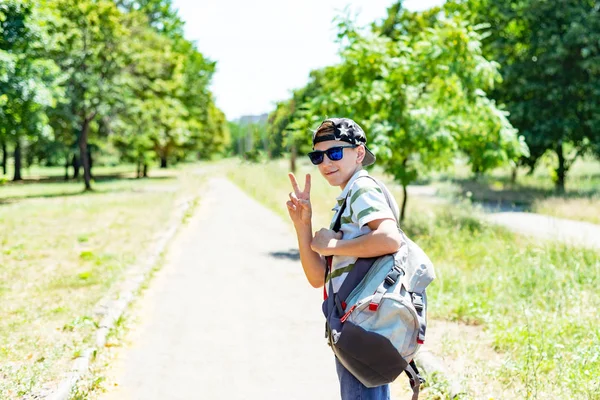 Élégant gars dans une casquette et des lunettes de soleil et un sac à dos va étudier . — Photo