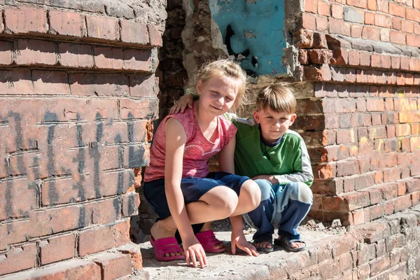 Fratello e sorella sono stati lasciati soli a causa di conflitti militari e disastri naturali. Bambini in una casa in rovina e abbandonata. Foto in scena . — Foto Stock