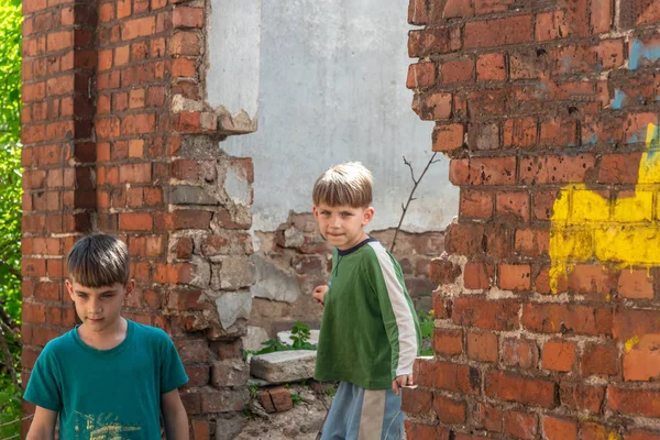 Dois irmãozinhos são órfãos, vivendo em uma casa abandonada e abandonada, filhos de guerra. Foto encenada . — Fotografia de Stock