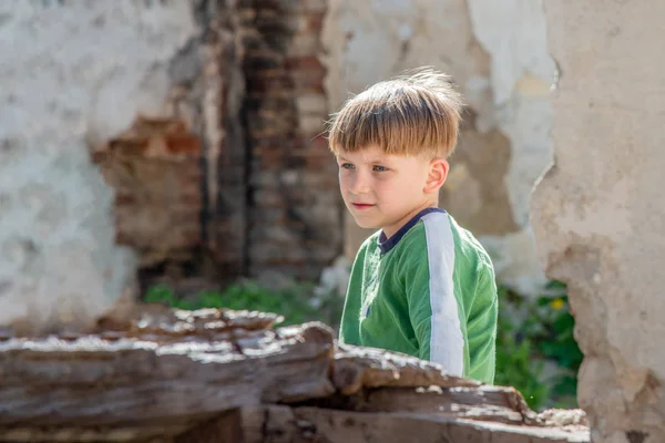 Pobres huérfanos en el contexto de edificios destruidos, el concepto de la vida de los niños de la calle. Foto escenificada. —  Fotos de Stock