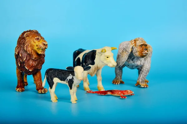 Toy animals made of plastic on a blue background, baby little animals.