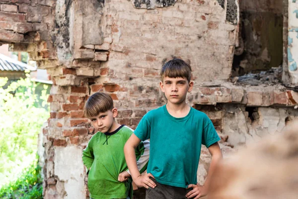 Dois irmãos tristes e infelizes em um prédio destruído e abandonado, foto encenada. — Fotografia de Stock