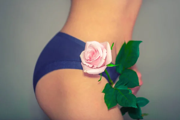 Meisje met een roos in ondergoed, het concept van gynaecologie en vrouwelijke hygiëne. — Stockfoto