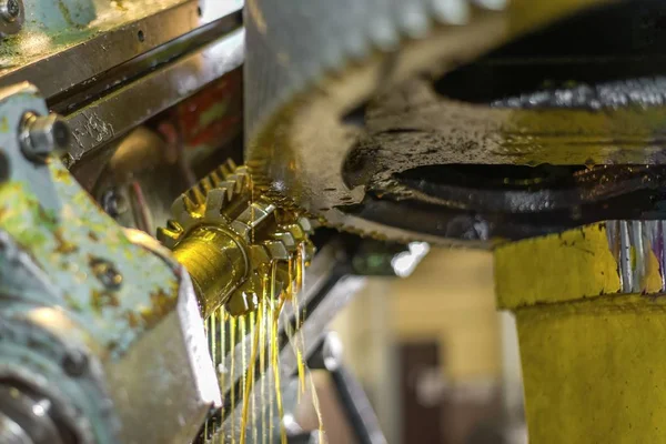 Produkcja kół zębatych w przedsiębiorstwie budowy maszyn, produkcja koła zębatego na maszynie, z chłodzeniem olejem. — Zdjęcie stockowe