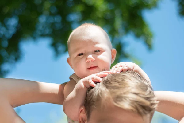 Un bambino piccolo è seduto sul collo di suo padre . — Foto Stock