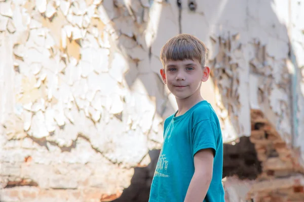 Niños en un edificio abandonado y destruido en la zona de conflictos militares y militares. El concepto de problemas sociales de los niños sin hogar. Foto escenificada . —  Fotos de Stock