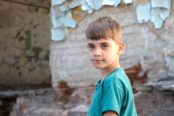 Barn i en övergiven och förstörd byggnad i zonen av militära och militära konflikter. Begreppet hemlösa barns sociala problem. Iscensatt foto. — Stockfoto