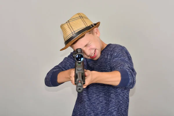 Un chico con un rifle de aire mira a la vista. . — Foto de Stock