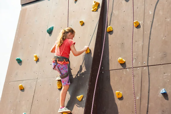 Dziewczyna na wieży wspinaczy pokona szczyty w ekstremalnym parku. — Zdjęcie stockowe