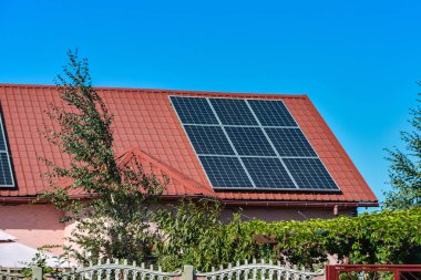 Bir kır evinin çatısında güneş panelleri, elektrik güneş enerjisi çevresel üretim.