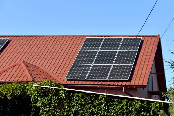 Sonnenkollektoren auf dem Dach eines Landhauses, ökologische Produktion von Sonnenenergie in elektrischer Energie. — Stockfoto