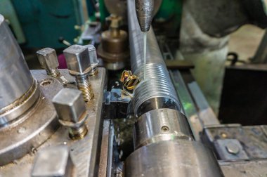 Mekanik kesici ile bir torna üzerinde, bir şaft üzerinde iplik kesme.