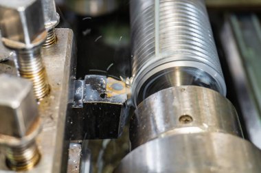 Mekanik kesici ile bir torna üzerinde, bir şaft üzerinde iplik kesme.