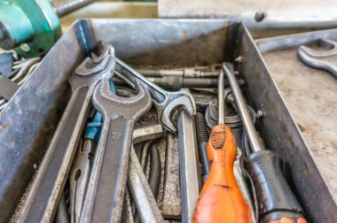 Onarım işlemi sırasında bir tamircinin fitter, open-end anahtarları ve tornavidaların çalışma aletleri bir dizi metal bir kutu bulunmaktadır.