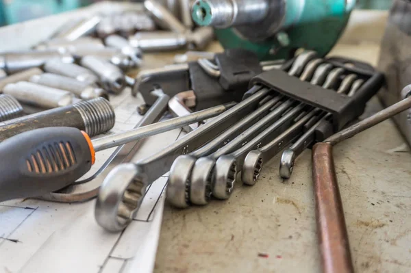 A set of working tools of a repairman's fitter, open-end wrenches and screwdrivers are in a metal box during the repair process.
