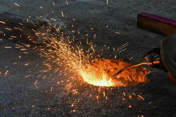 Üretimde bir gaz kesici, bir kaynakçı bir gaz kesici ile gereksiz metal kalıntıları kaldırır, kıvılcım farklı yönlere uçmak. — Stok fotoğraf