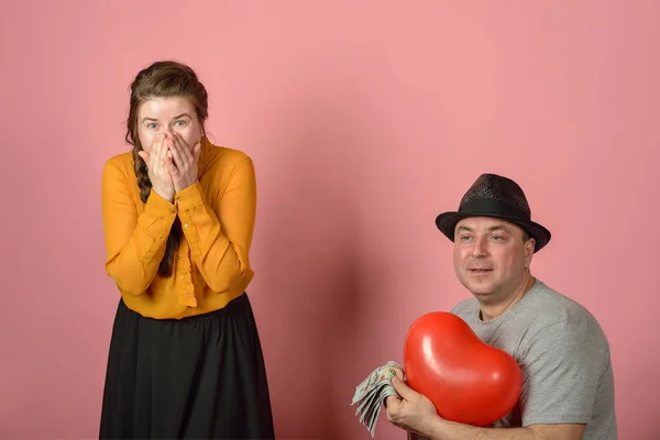 stock image A man gives a balloon, in the form of the heart of his beloved, congratulations among lovers.