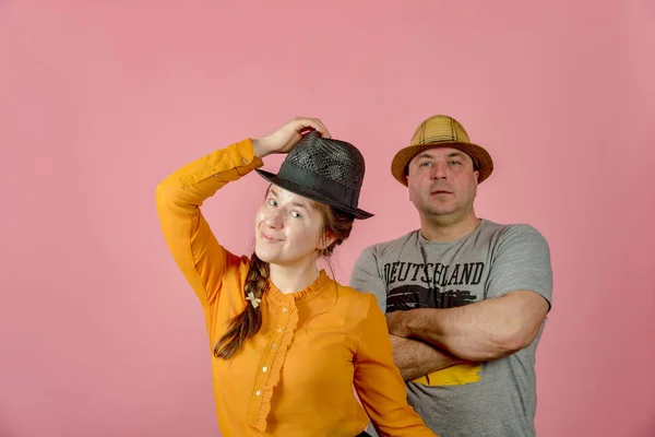 一个男人和一个女人戴着一顶红帽子，在演播室里摆姿势给摄像机. — 图库照片