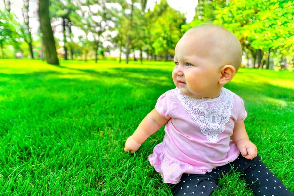 Маленька дівчинка сидить на зеленій траві, крупним планом . — стокове фото