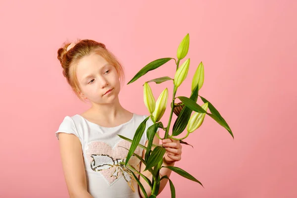 Fille à la mode et glamour avec une fleur dans le studio sur un fond rose . — Photo