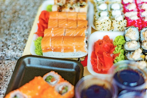 Sushi in a restaurant, Asian national seafood, a set of rolls of fish food with Chinese chopsticks.