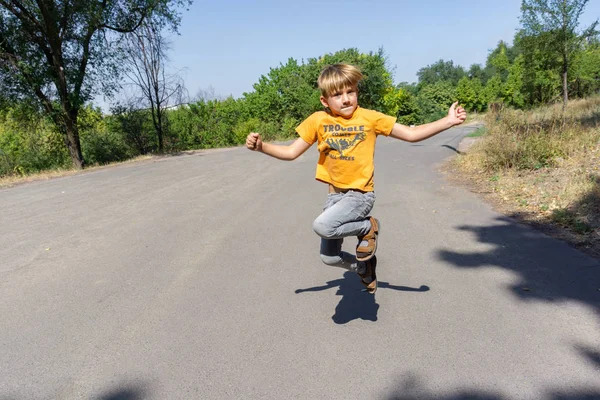 आनंदी आणि आनंदी मुलगा रस्त्यावर उडी मारत आहे . — स्टॉक फोटो, इमेज