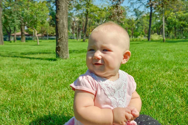 A child on the green grass is played in the park. — Stock Photo, Image