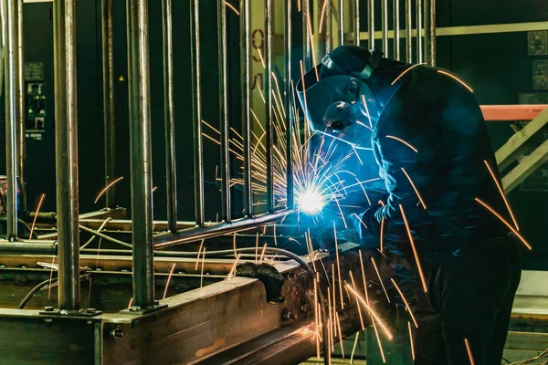 The welder assembles the metalwork at the enterprise by welded joints. — Stock Photo, Image