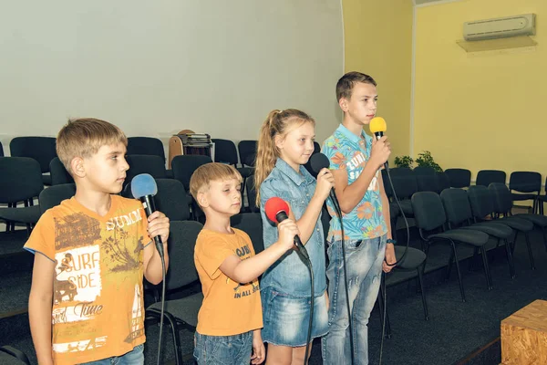 Kinder nehmen am Mikrofon teil, rezitieren Gedichte, rezitieren, singen Lieder. — Stockfoto