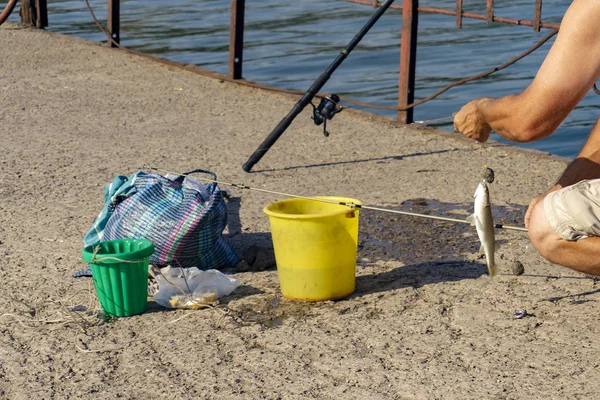 Il pescatore catturato il pesce e lo rimuove dal gancio . — Foto Stock