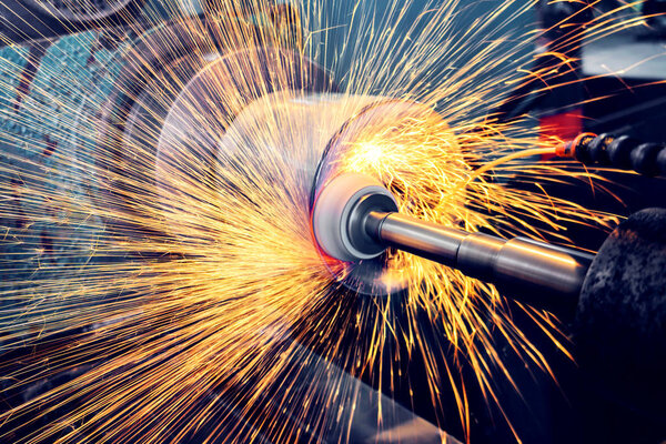 Grinding a cylindrical part on a circular grinding machine, high-precision abrasive grinding with sparks.