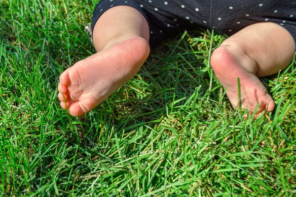 Маленький ребенок на траве, маленькие ноги на зеленой траве в р — стоковое фото
