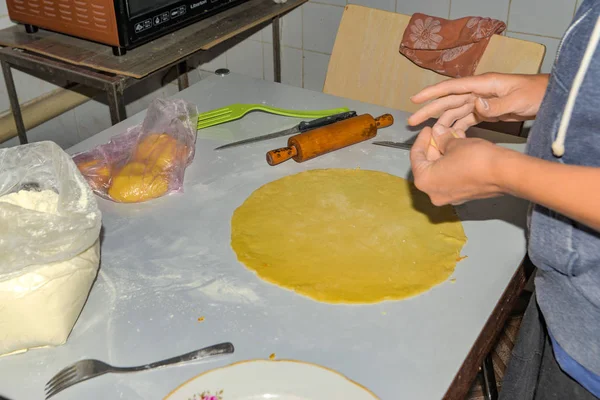 Kobieta toczy ciasto za pieczenie chleba pita w piekarniku. — Zdjęcie stockowe