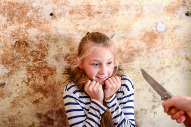 Adam kızın boğazına bıçak dayadı, onu soymaya ya da öldürmeye çalıştı. Yapım fotoğrafı.