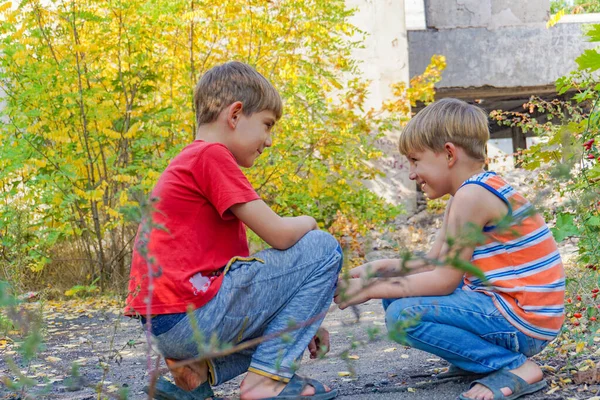 Zwei Jungen sitzen sich im Park gegenüber und kommunizieren mit Witz — Stockfoto