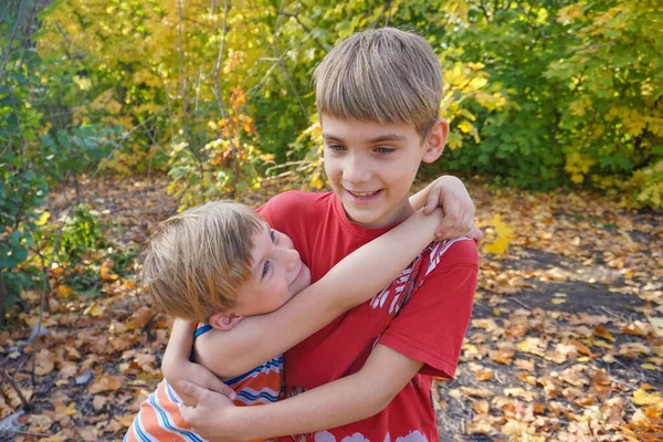 Młodszy brat przytula starszego i patrzy na niego, dwie miłości — Zdjęcie stockowe