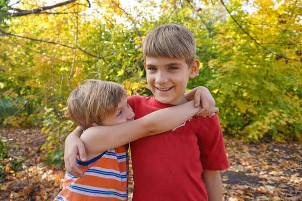 Młodszy brat przytula starszego i patrzy na niego, dwie miłości — Zdjęcie stockowe