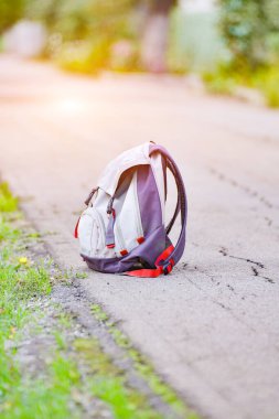 Sırt çantası yolun kenarında, kaldırımın kenarında, yalnız seyahat etme konsepti..