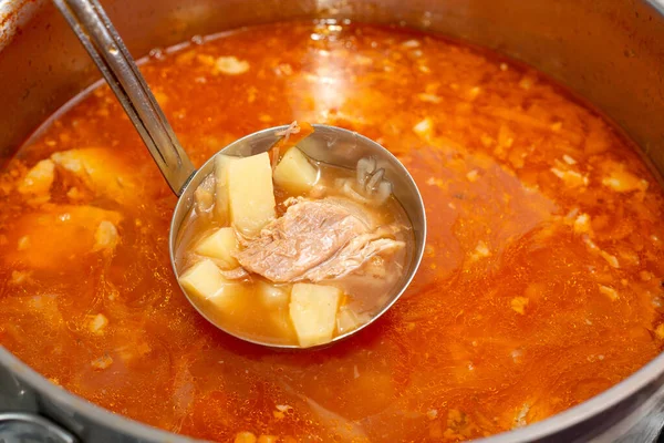 Красный борщ в кастрюле с капустой и жиром, мясо в ковше для супа . — стоковое фото