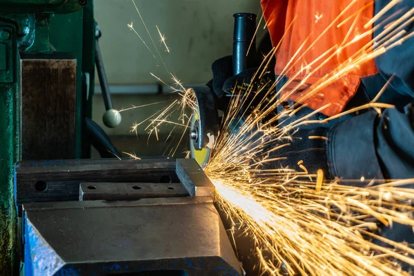 Metallskärning med vinkelslipmaskin med slipskiva, gnistor i verkstad. — Stockfoto