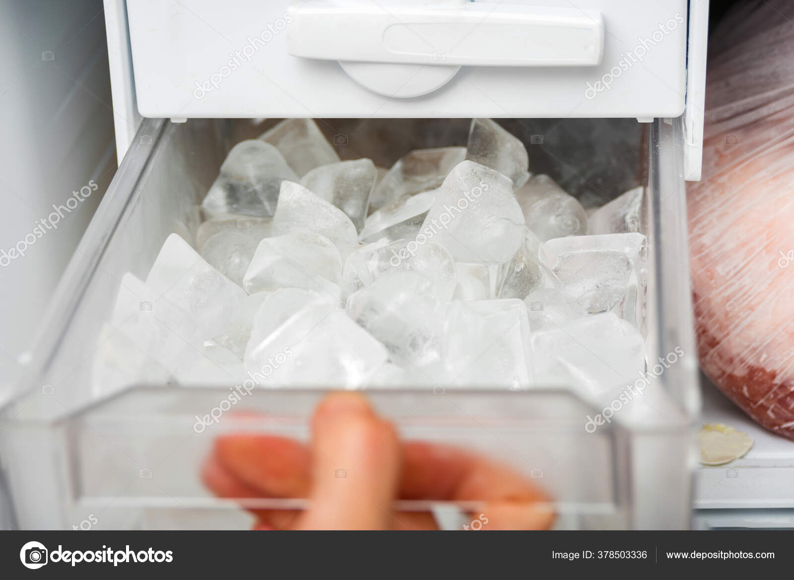 A Woman Opens An Ice Maker Tray In The Freezer To Take Ice Cubes To Cool  Drinks. Stock Photo, Picture and Royalty Free Image. Image 147627293.