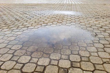 A pool of water after rain on a tile in the yard clipart