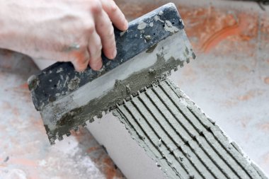 Bir işçi özel bir evdeki duvar bloğuna harç harcı uygular. Köpük ustalığı, onarım ve inşaat