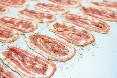 Masada ince dilimlenmiş sarımsak ve baharatlı pastırma var. Abur cubur pişirmek ve yağlı yiyecekler