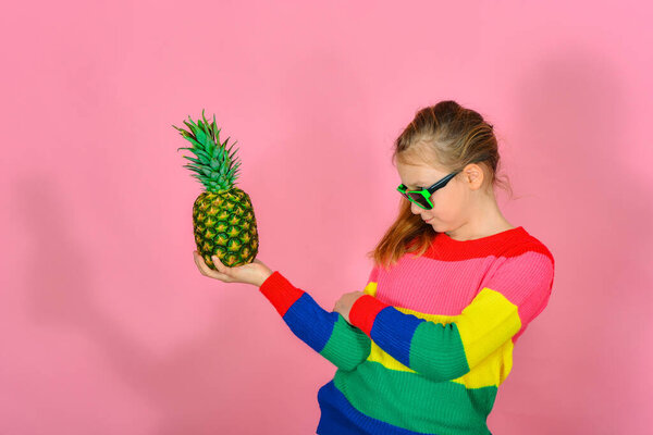 Девушка эмоционально смотрит на ананас в очках
.