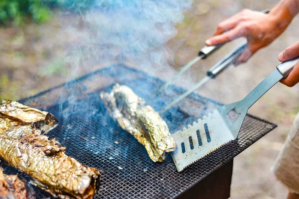 厨师在网上把鱼煎了 然后把它翻过来放在火上 户外烧烤周末 — 图库照片