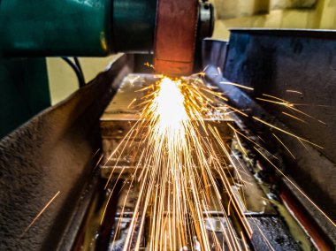 Makinede öğütülen metal, kıvılcımlar hazneye doğru uçar. Ön görünüm