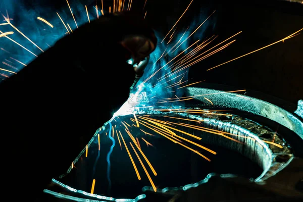 Sparks from electro gas welding at work in an electromechanical workshop.