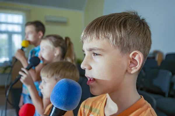 자녀들은 마이크로폰 가지고 참여하고 암송하고 암송하고 노래를 부른다 — 스톡 사진